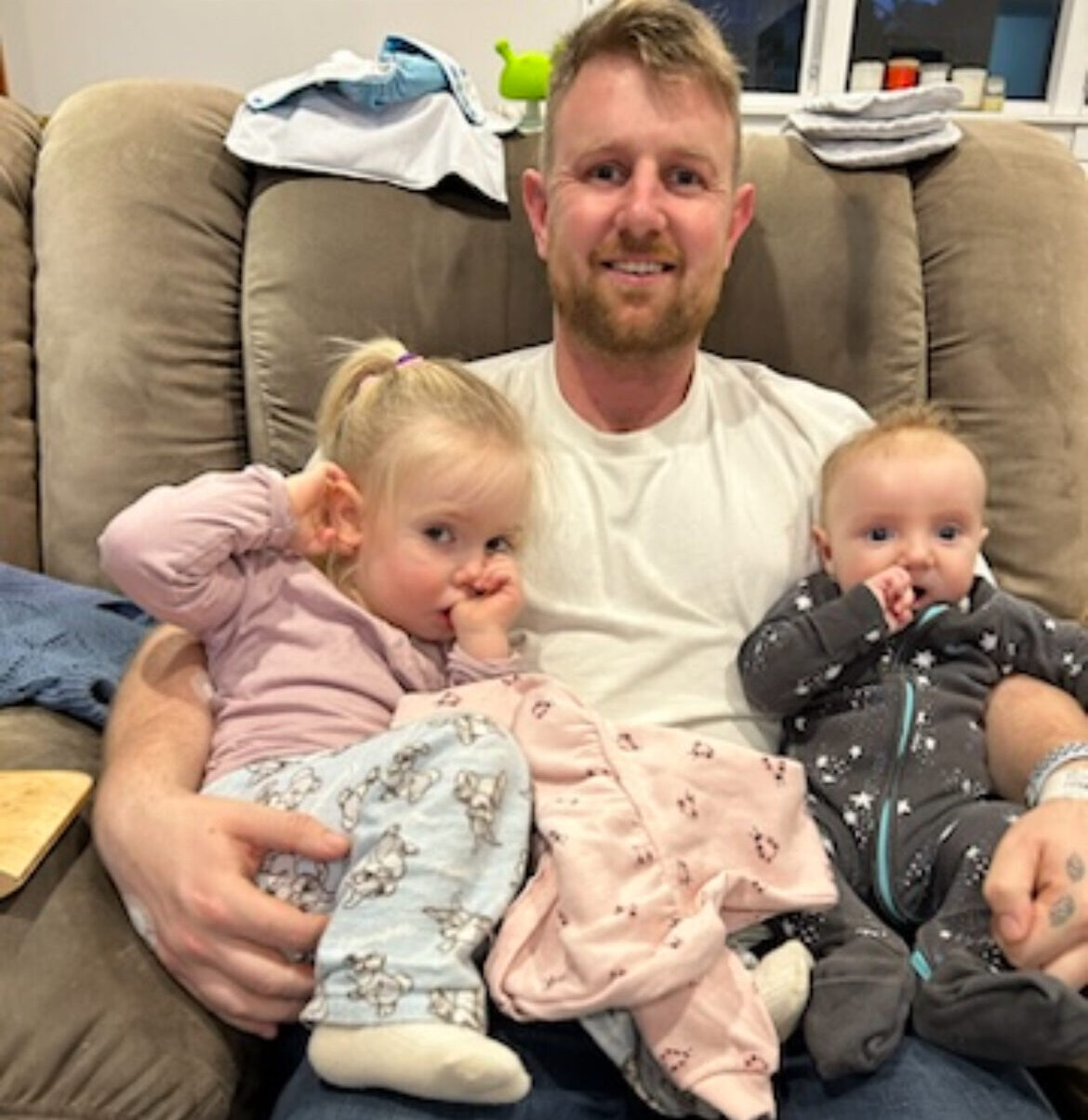 Chris sitting with his arms round his two young children
