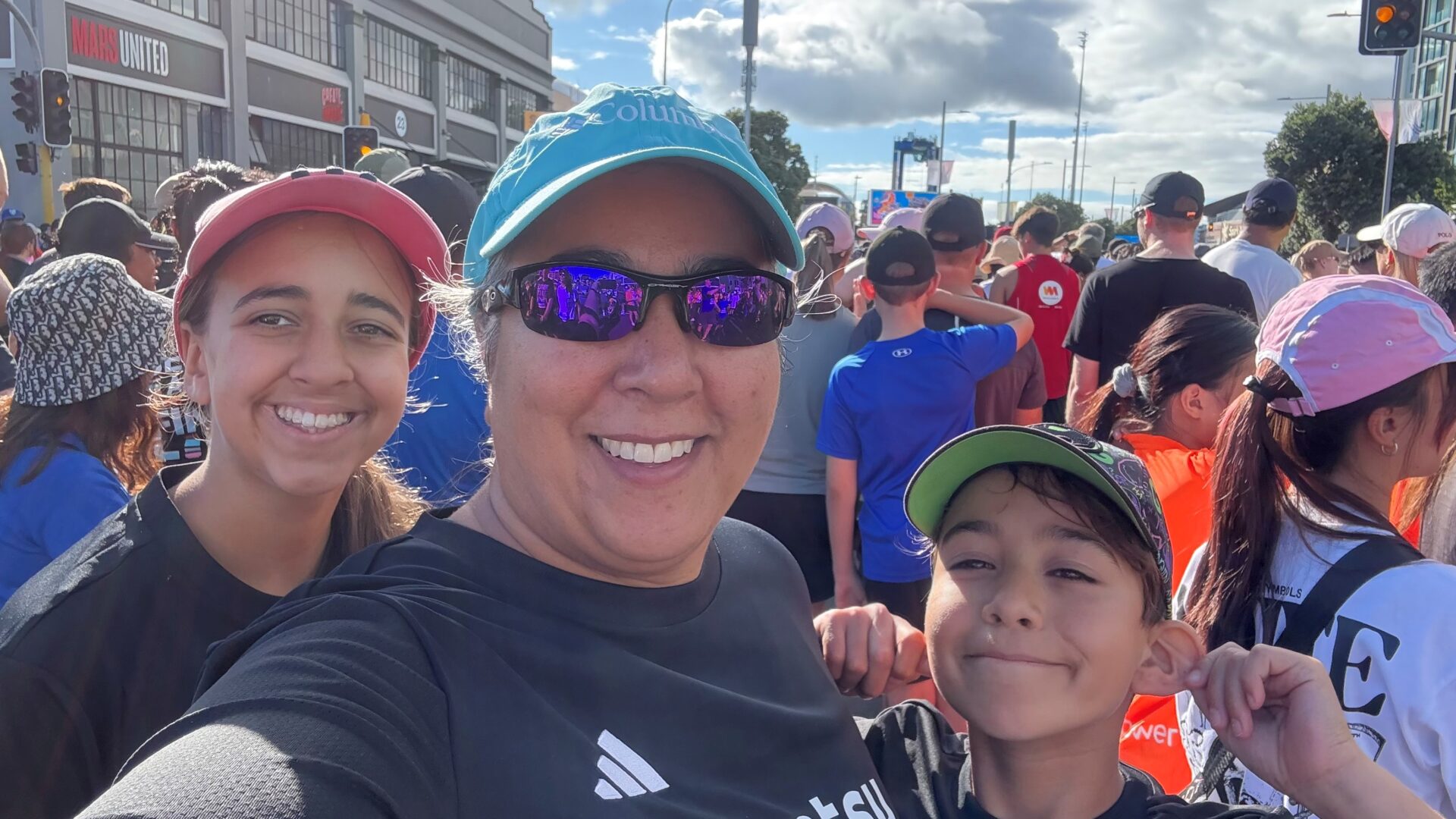 Anita smiling with cap and her children all smiling