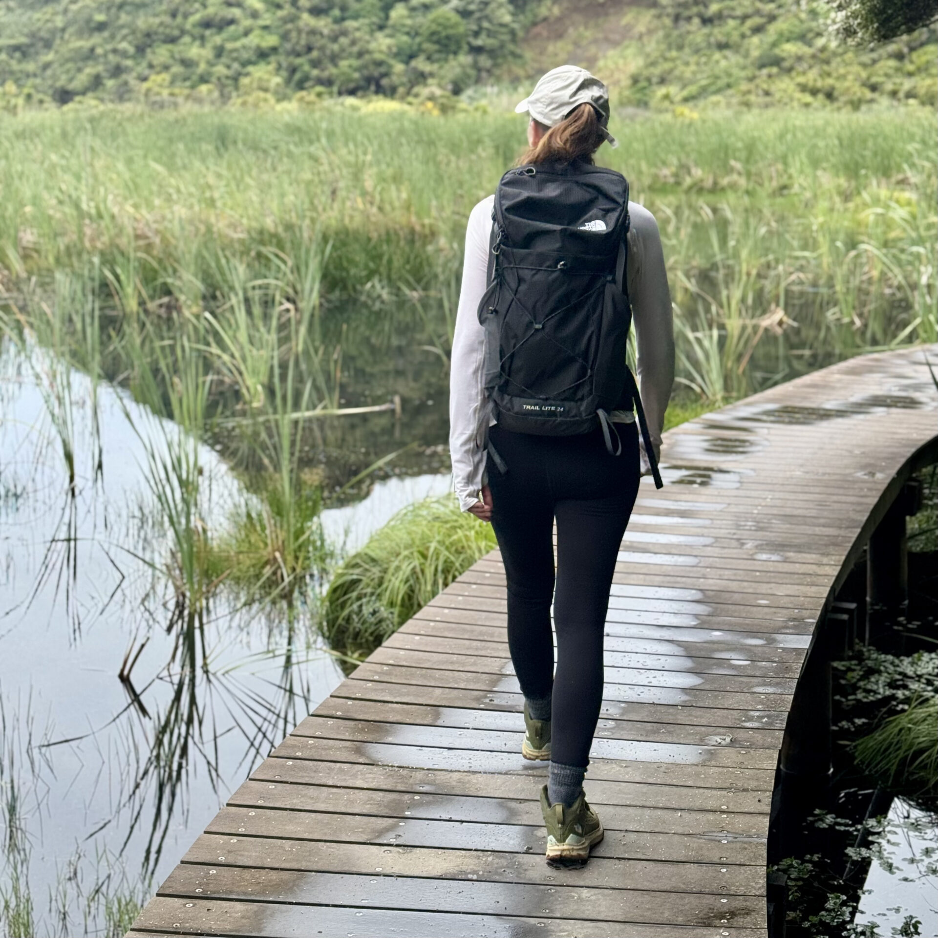 A photograph of the back of Stephanie walking a pathway
