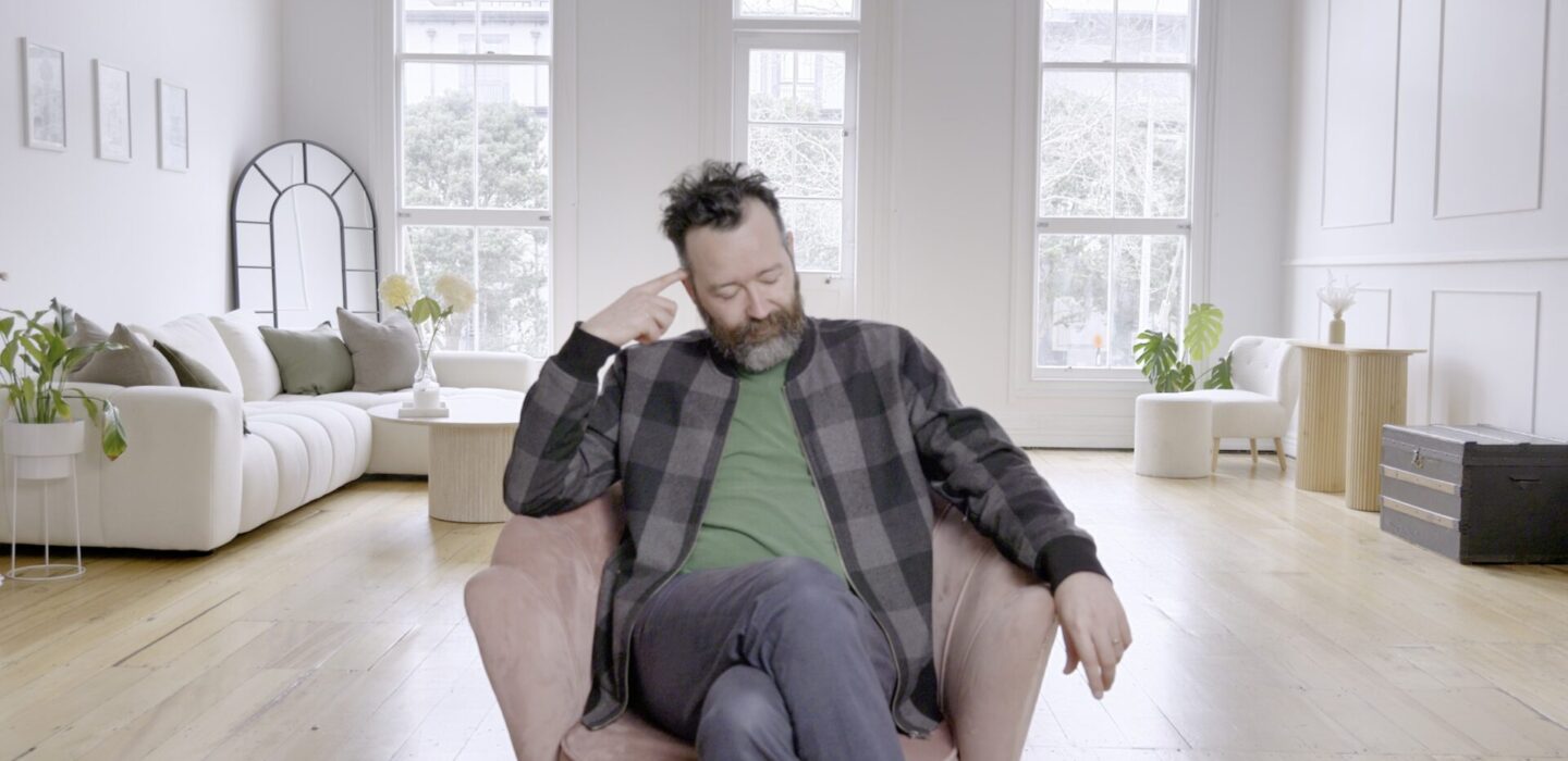 Sam Smith on chair looking thoughtful